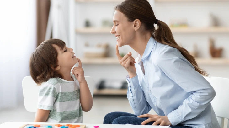 Mãe e filho olhando um para o outro com a mão no queixo